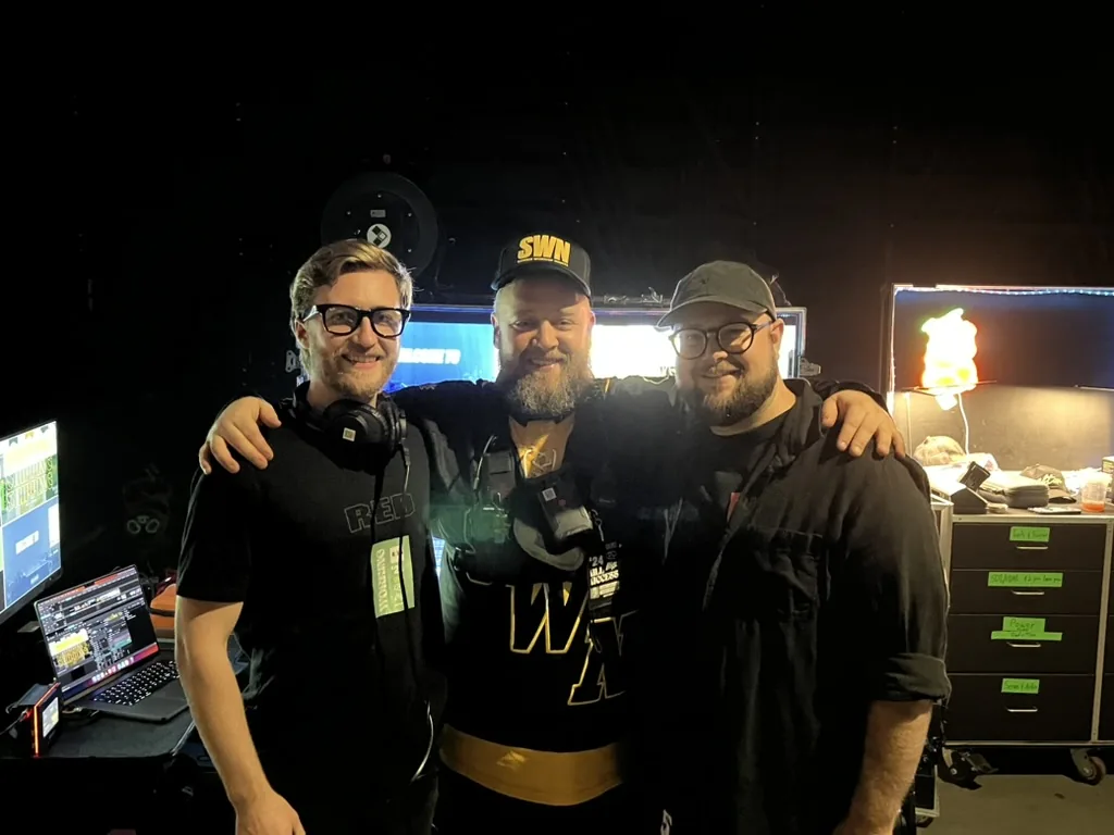 Three crew members backstage during a show